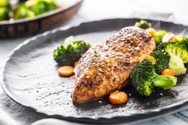 Brokoli havuç ve susam ile kavrulmuş tavuk göğsü.