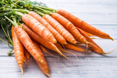 Ahşap masa üzerinde taze havuç demet.