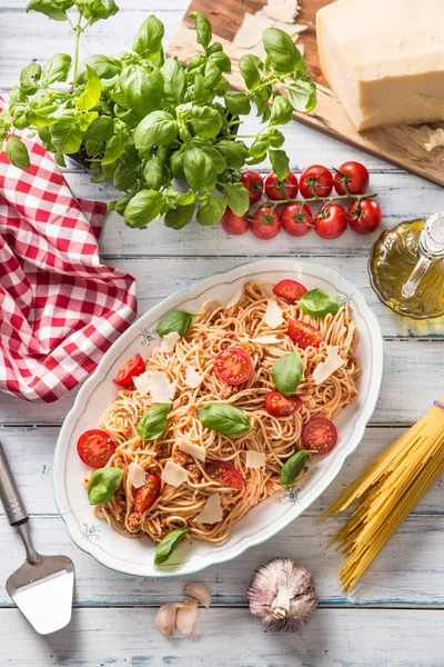 Pasta italiana espaguetis boloñesa en tazón blanco con tomates queso parmesano y albahaca —  Fotos de Stock