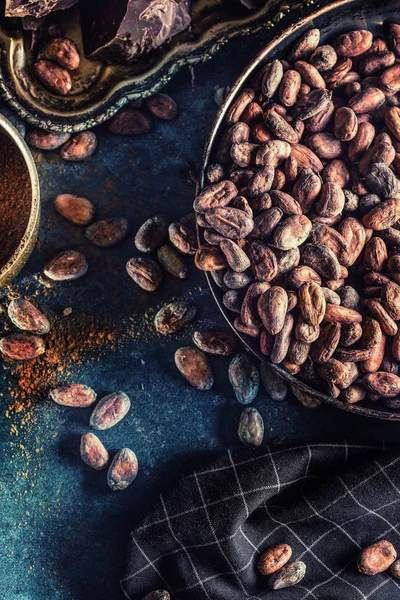 Mörk choklad kakaobönor och pulver på konkreta bord — Stockfoto