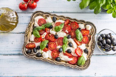 Caprese salatası mozzarella peynir olgunlaşmış domates zeytin ve fesleğen yaprakları. İtalyan ya da Akdeniz sağlıklı yemek.