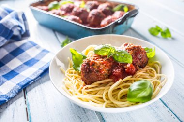 Delisious İtalyan yemek sığır eti köfte makarna spagetti ve beyaz tabak içinde fesleğen ile.