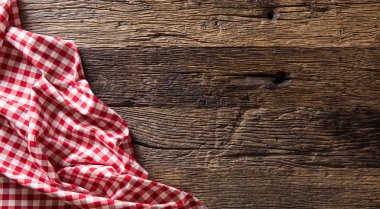 Rustik ahşap masa üzerinde kırmızı kareli mutfak masa örtüsü.