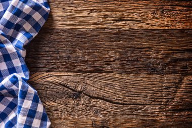 Rustik ahşap masa üzerinde mavi kareli mutfak masa örtüsü.