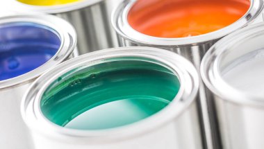 Beyaz masaya çok renkli boya dolu kutular. 