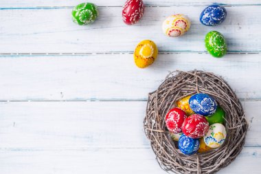 Yakın çekim çok renkli Paskalya yumurtaları sepeti ahşap tablo.