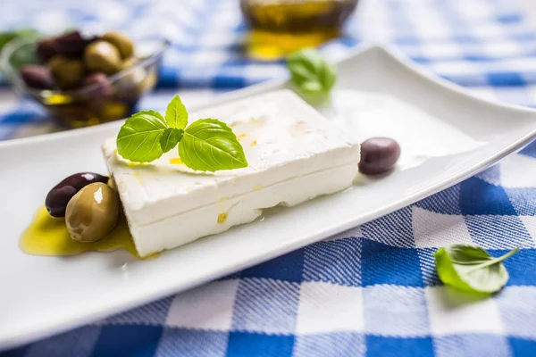 Grekisk ost fetaost med olivolja oliver och basilikablad — Stockfoto