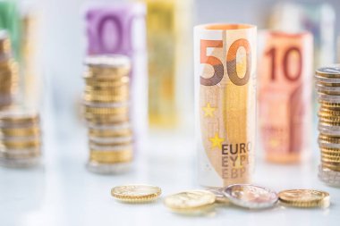 Diğer konumda haddelenmiş euro banknot ve madeni paraların kuleleri yığılmış