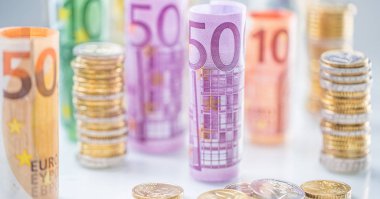 Diğer konumda haddelenmiş euro banknot ve madeni paraların kuleleri yığılmış