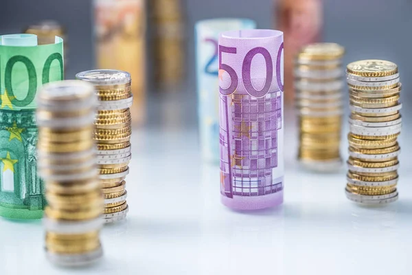 Rolled euro banknotes and coins towers stacked in other position