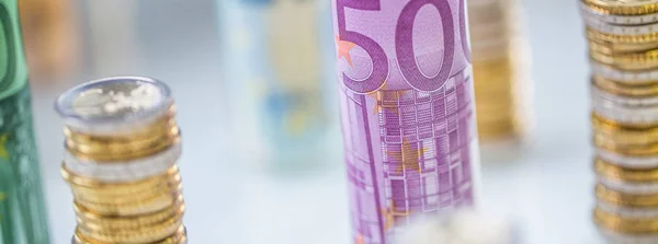 Rolled euro banknotes and coins towers stacked in other position — Stock Photo, Image
