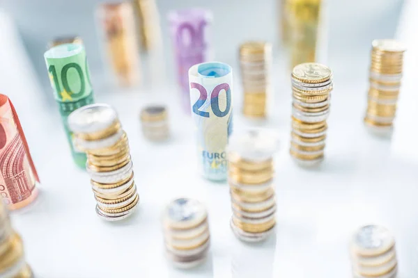 Rolled euro banknotes and coins towers stacked in other position — Stock Photo, Image