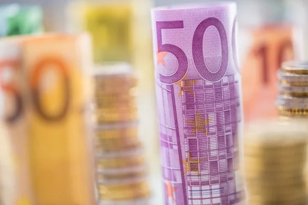 Gerollte Euro-Banknoten und Münztürme in anderer Position gestapelt — Stockfoto