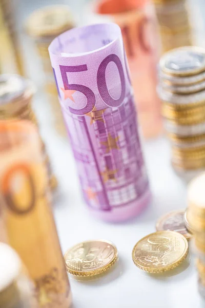 Gerollte Euro-Banknoten und Münztürme in anderer Position gestapelt — Stockfoto