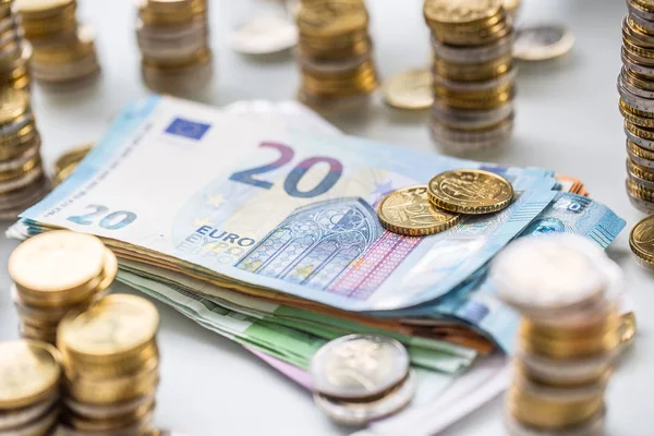 Euro-Banknoten und -Münzen zusammen auf weißem Tisch - Nahaufnahme — Stockfoto