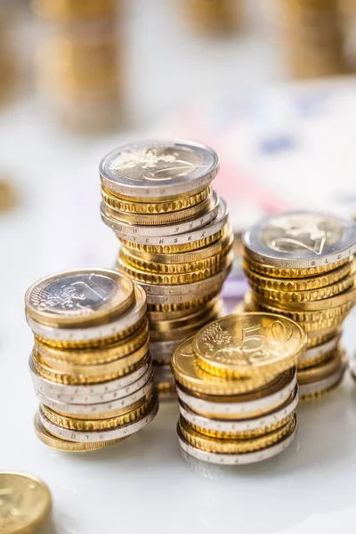 Euro bankbiljetten en munten togetger op witte tafel - close-up — Stockfoto