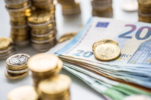 Euro-Banknoten und -Münzen zusammen auf weißem Tisch - Nahaufnahme — Stockfoto