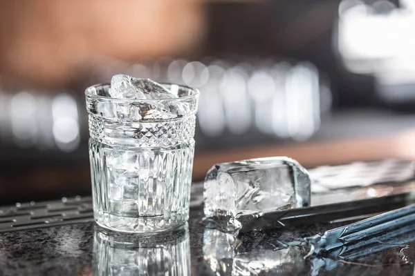Isbitar i glaset vid barcounter i nattklubb eller restaurang — Stockfoto
