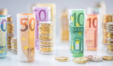Diğer pozisyonlarda haddelenmiş euro banknot ve madeni paraların kuleleri yığılmış