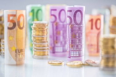 Diğer pozisyonlarda haddelenmiş euro banknot ve madeni paraların kuleleri yığılmış