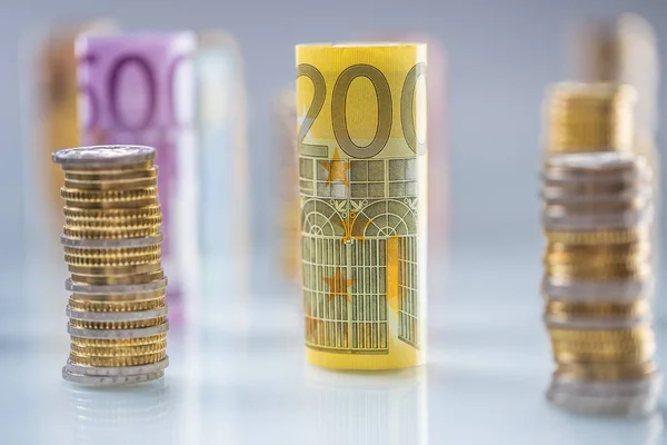 Gerollte Euro-Banknoten und Münztürme in anderen Positionen gestapelt — Stockfoto