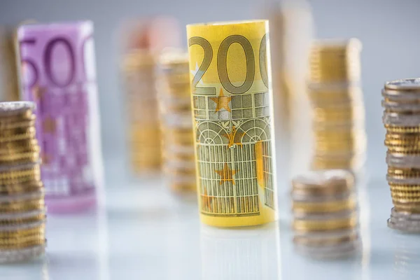 Rolled euro banknotes and coins towers stacked in other positions