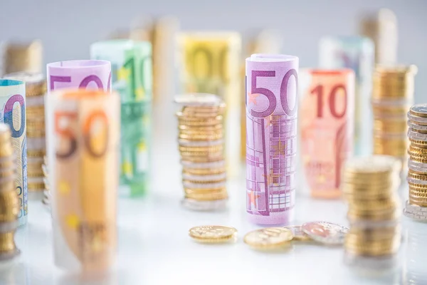 Gerollte Euro-Banknoten und Münztürme in anderen Positionen gestapelt — Stockfoto