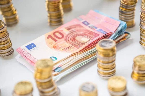 Euro-Banknoten und -Münzen zusammen auf weißem Tisch - Nahaufnahme — Stockfoto