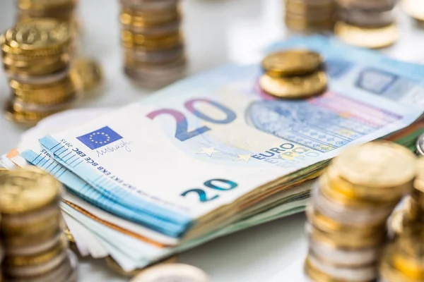 Euro-Banknoten und -Münzen zusammen auf weißem Tisch - Nahaufnahme — Stockfoto