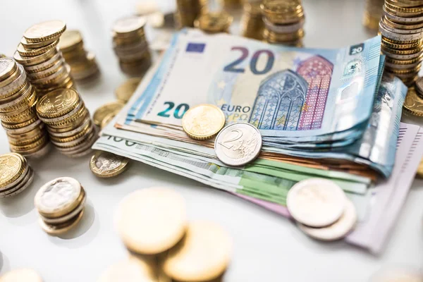 Euro-Banknoten und -Münzen zusammen auf weißem Tisch - Nahaufnahme — Stockfoto