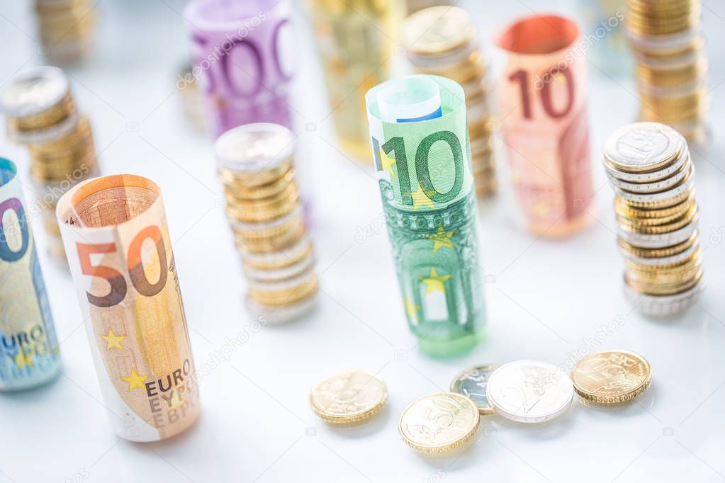 Rolled euro banknotes and coins towers stacked in other positions