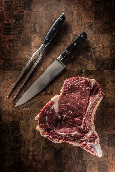 RIB eye steak med ben på slaktare ombord med gaffel och kniv — Stockfoto