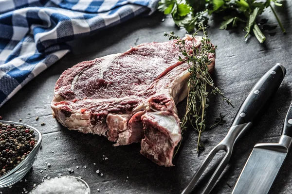 Filete de costilla con hueso en carnicero con hierbas sal pimienta tenedor y cuchillo — Foto de Stock