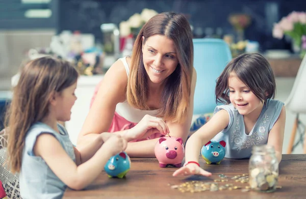 Mutlu aile anne kızı kurtarmak para kumbara gelecekteki CEOlarla — Stok fotoğraf