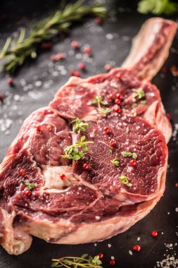 Ham sığır eti biftek tuz biber ve biberiye kayrak plaka üzerinde tomahawk