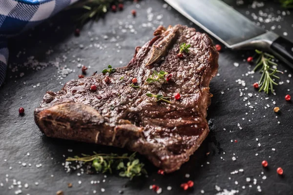 Beef T-Bone steak with salt pepper and rosemary on slate plate — Stock Photo, Image