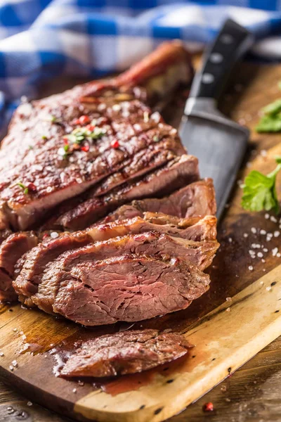 Carne de tomahawk recién asada en plato de pizarra con sal pimienta romero y hierbas de perejil. Trozos rebanados de jugoso bistec de res — Foto de Stock