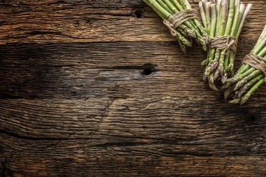 Eski meşe masasında taze yeşil kuşkonus