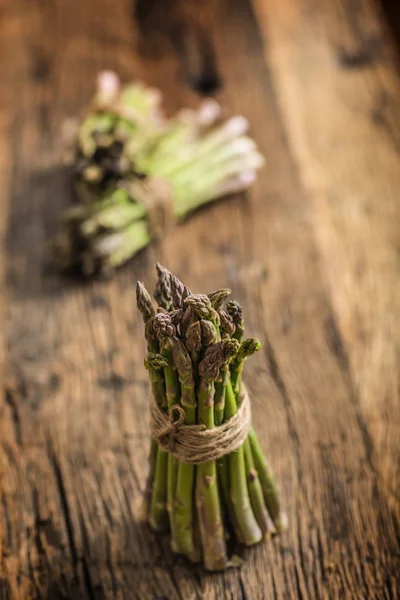 Fresh green asparagus on old oak table — Stock Photo, Image