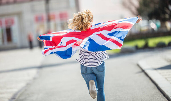 Attractive happy young girl with the flag of the Great Britain