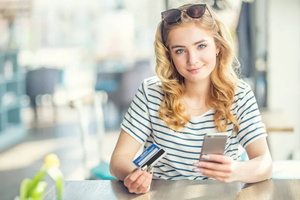 Mujer joven en el café con tarjeta de crédito y el uso de la celda, smar — Foto de Stock