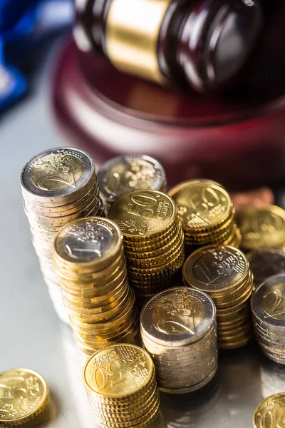 Torres con monedas en euros y martillo de justicia en segundo plano — Foto de Stock