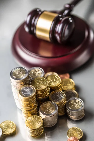 Torres con monedas en euros y martillo de justicia en segundo plano — Foto de Stock