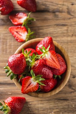 Sulu mutfak masasında ahşap kase çilek yıkanmış