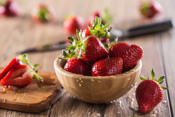 Šťavnaté jahody v dřevěné misce na kuchyňském stole — Stock fotografie