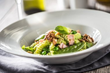 Yeşil bezelye jambon ve ceviz ile Fusilli makarna. İtalyan veya Akdeniz mutfağı