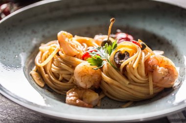 Makarna spagetti tabakve karides domates sosu toatoes ve otlar ile tavada. İtalyan veya Akdeniz mutfağı