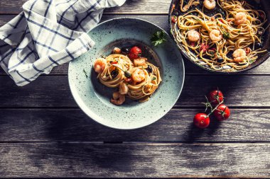 Makarna spagetti tabakve karides domates sosu toatoes ve otlar ile tavada. İtalyan veya Akdeniz mutfağı