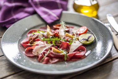 Kurutulmuş domates enginar arugula ve parmesan peyniri ile plaka Sığır carpaccio