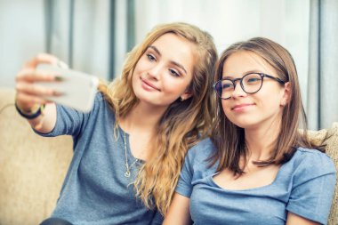 İki genç kız gülümseme ve birlikte selfie çekmek.